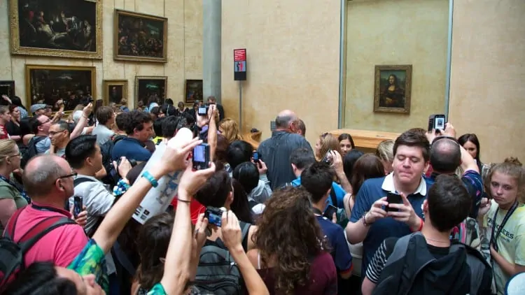 Visitors looking at Mona Lisa at Louvre Museum