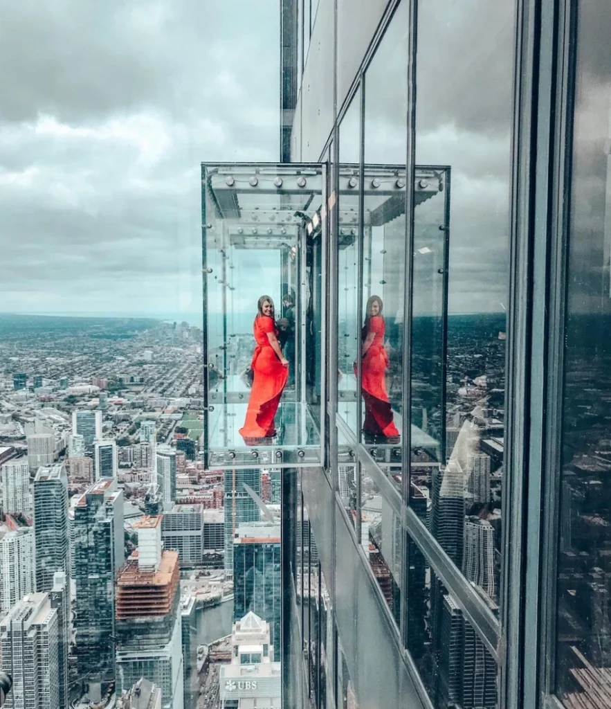 Guest in Skydeck Chicago enjoys the height