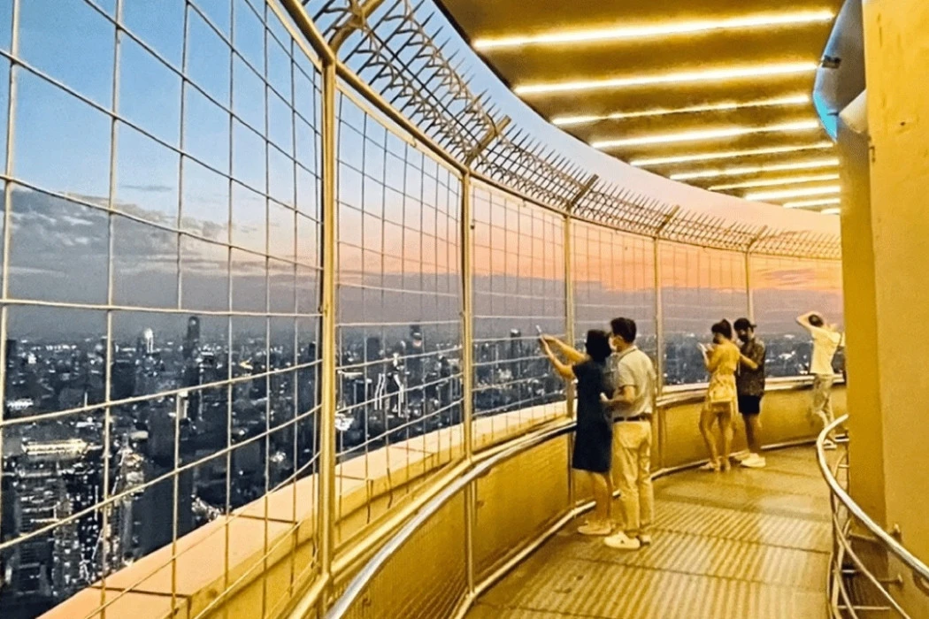 Tourists capturing views at the Baiyoke Observation Deck dressed in comfortable casual wear.