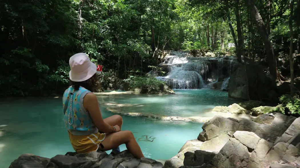 A tourist enjoying her trip to the Erawan waterfalls