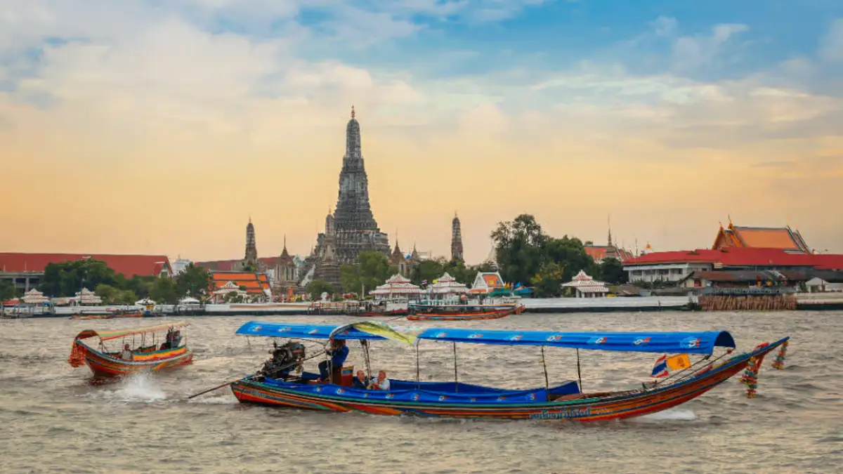 Longtail Boat canal cruise on the Chao Phraya river with the backdrop of the Temple of Dawn