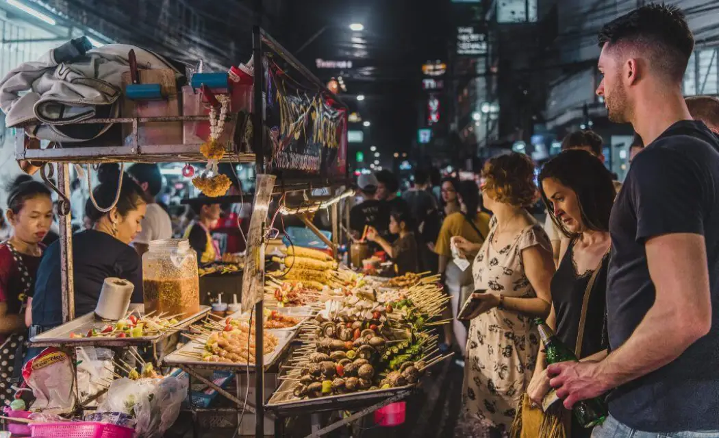 Tourists exploring the local markets in the Bangkok Food Tour