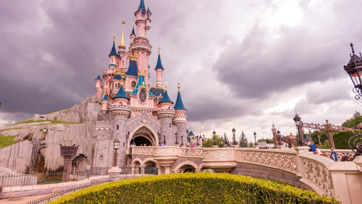 Sleeping Beauty Castle at Disneyland Paris under cloudy skies