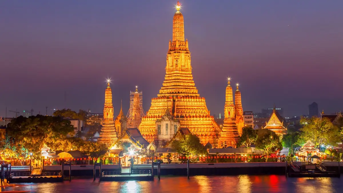Wat Arun temple illuminated at night with bright lights