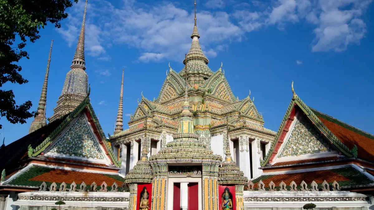 extérieur du temple Wat Pho Toit orné et flèches colorées du temple Wat Pho sous un ciel bleu